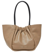 The Large Ruched Tote by Proenza Schouler features beige leather with a ruched top, sleek black handles, and a subtle logo stamp for added elegance.
