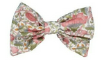 The Kidiwi Bonnie Hair Clip is a large bow adorned with a floral print in pink, green, and grey on a crisp white background.