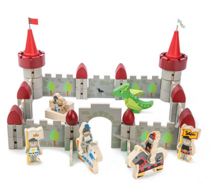 The Dragon Castle by Tender Leaf Toys features red towers, grey walls, a green baby dragon, and illustrated wooden knights and figures arranged around and inside the castle.