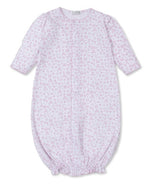 The Baby Royal Details Pink Convertible Gown by Kissy Kissy, made from soft Pima cotton, is pink and white with long sleeves, a gathered bottom, and a pattern of tiny letters and shapes. Clever snaps transform it into a playsuit for added versatility.