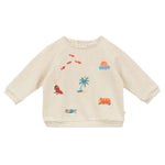 The Baby Faustin Sweatshirt by Arsene & Les Pipelettes is a relaxed, cream-colored children’s sweatshirt featuring colorful embroidered designs like a palm tree, fish, seal, van, sunrise, and a fish in water.