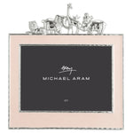 The Michael Aram Animals Nickelplate Frame, 5x7 in pink, features a silver giraffe, elephant, lion, and monkey along the top—an adorable way to showcase joyful children’s memories.