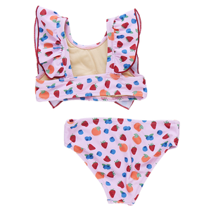 The Girls' Katniss Bikini by Pink Chicken is a delightful two-piece swimsuit for children, with a vibrant fruit pattern of blueberries and strawberries and charming ruffled straps.