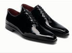 A pair of Cruz II Tux Shoes by Magnanni—black patent leather oxford dress shoes with laces, a glossy finish, and low heel—ideal for formal wear, displayed on a white background.