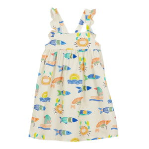 The Girls' Fredine Dress by Arsene & Les Pipelettes is a sleeveless apron style with a vibrant ocean print featuring colorful fish and boats on a white background.