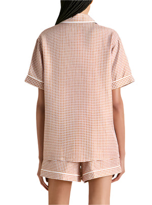 Person wearing Olivia von Halle Ingo Silk Pajamas—short-sleeve shirt and shorts—featuring a small geometric motif, shown from the back.