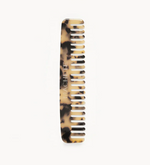 The Machete Comb No. 3, a tortoiseshell-patterned wide-tooth comb made from Italian bio-acetate and engraved with the brand name, is displayed against a plain white background.