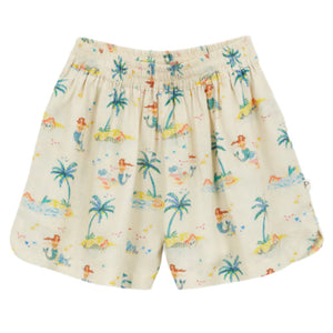 The Girls' Fayza Shorts by Arsene & Les Pipelettes feature an elastic waistband and a playful print of palm trees, mermaids, and people relaxing on a cream background.
