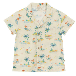 The Kids' Federico Shirt by Arsene & Les Pipelettes is a short-sleeved cream shirt featuring a vibrant mermaid print with palm trees and beach scenes, plus a collar, front buttons, and chest pocket.