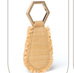 The Fray Raffia Hat Clip by Toptote, featuring a hexagonal metal keyring and a fringed beige fabric piece, provides stylish adventurers with the ultimate hands-free hat carrier for carefree travel.