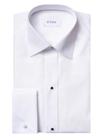 The Eton Pique Black Tie Tux Shirt is an elegant white dress shirt with a spread collar and black buttons, perfect for black-tie events. Designed to accommodate removable studs, it adds flair to any evening piqué ensemble.