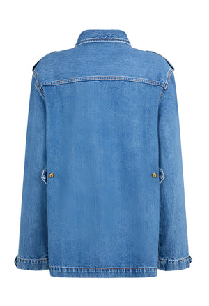 The Nariida Sahariana by Blaze Milano is displayed from the back, featuring a relaxed fit and long sleeves with a collar and buttoned side details in light blue denim.