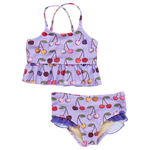 The Girls' Joy Tankini by Pink Chicken is a purple two-piece swimsuit with a charming cherry pattern, featuring a sleeveless top with a ruffled hem and matching bottoms, embodying carefree joy.