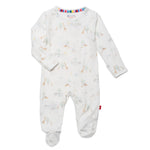The Baby White Serene Safari Footie by Magnetic Me is a white onesie featuring pastel giraffes, elephants, and trees. Made from eco-friendly TENCEL™ modal, it offers temperature regulation with long sleeves, footed bottoms, and magnetic closures for easy dressing.