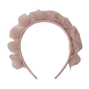 The Noralee Pixie Headband showcases pink layered fabric petals, adding a magical touch to any outfit. Shown on a white background.