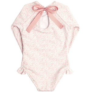 A pink floral-patterned baby onesie with long sleeves, an open back, a pink bow at the top, and ruffle hip detail. Made from buttery soft fabric for ultimate comfort is Minnow Girls' Rashguard One Piece by Minnow.
