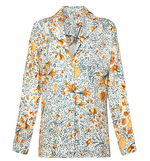 Chic and versatile, the Silice Shirt by Agua By Aguabendita features long sleeves, a button-up front, and a yellow, orange, and green floral pattern on a white background.