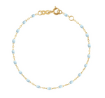 The Little Gigi Classic Bracelet 5.1" by Gigi Clozeau showcases an elegant 18-carat gold chain with small light blue bead accents, beautifully set against a white background.
