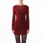 A person wears the Jason Wu LS Double Layer Ruched Dress in rich burgundy, paired with black tights, standing against a plain white background.