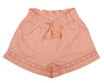 The Early Sunday Girls' Roman Shorts are peach-colored with a floral eyelet pattern, made from a cotton-linen blend. They feature an elastic waistband and a tassel bow, making them perfect for warm days.