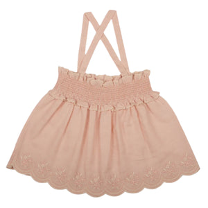 The Girls' Olivia Blouse by Early Sunday features crisscross straps, a smocked bodice, and an embroidered scalloped hem on a white backdrop.