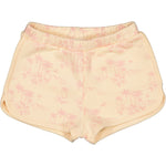 The Girls' Georgia Short by Louis Louise features a beige cotton design with a light pink tropical palm tree and floral print. They include an elasticated waist, side pockets, and curved hems for added comfort and style.