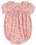 The Baby Girls' Pima Ramona Ruffle Bubble by The Beaufort Bonnet Company is a pink romper with short sleeves, a ruffled collar, and a Grand Cayman Gardens floral print in shades of pink, orange, and green.