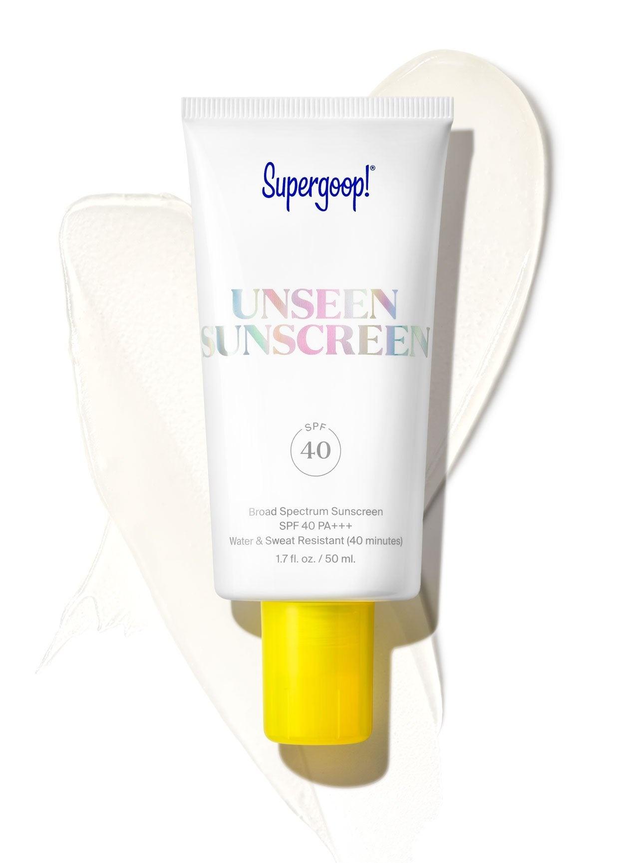 A tube of Supergoop Unseen Sunscreen SPF 40 is displayed on a white background with a smear of the invisible, weightless formula behind it.
