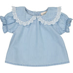 The Baby Girls' India Tunic by Louis Louise is a light blue cotton chambray dress with short sleeves, ruffled cuffs, and a white lace-trimmed Claudine collar.