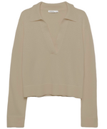 The Simkhai Cashmere Long Sleeve Polo Sweater features a beige hue, V-neckline, open collar, wide cuffs, ribbed hem, and is crafted from a soft cotton-cashmere blend.