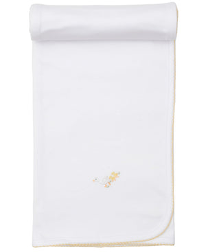 The Kissy Kissy Premier Baby Duckling Blanket with Hand Emb. is a white baby blanket with yellow trim, partially rolled at the top, and features an embroidered duck and ducklings near one corner.