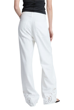 A person shown from the back wears Rag & Bone's Ultra Featherweight Phoebe Drawstring Eyelet Jeans in white with cut-out hem details, paired with a black top and black sandals.