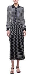 A person wears the Kassidy Polo Midi Dress by Simkhai—a long sleeve dress featuring a white wavy line pattern, black collar, and buttoned neckline—paired with black sandals.