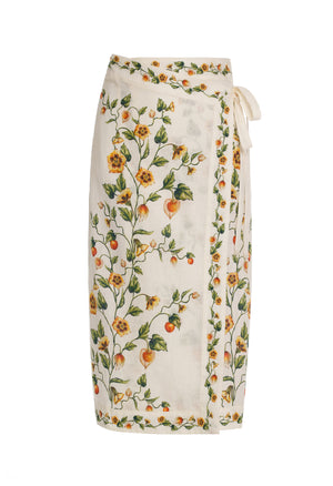 The Luna Midi Pareo by Agua By Aguabendita is a white skirt with a colorful floral and fruit print, featuring a chic tie waist closure.