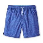 The Peter Millar Paloma Swim Trunk features a subtle floral print, elastic waistband with white drawstring, four-way stretch fabric, and small side vents at the hem.