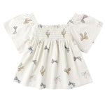 The Baby Girls' and Girls' Kate Top by Rylee & Cru features a smocked neckline and charming bows, bringing a sweet touch to this classic white top.
