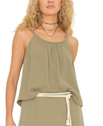 Someone with curly hair wears the Brandi Tank by Xirena paired with a matching skirt, layered necklaces, a white rope belt, and rocks a stylish twisted braid.