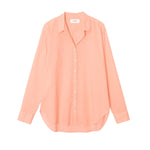 The Xirena Beau Shirt by Xirena is a long-sleeve, light peach cotton poplin shirt with a collar and button-up front, displayed against a white background.