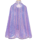 The Great Pretenders Sequins Cape in shimmering purple elegantly drapes over the mannequin's shoulders. Its eye-catching brilliance is enhanced by a lightweight design and discreet velcro closure for a seamless fit.