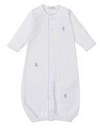 The Kissy Kissy Baby Teddy Bear Time Converter Gown with Hand Embroidery is made from premium Peruvian cotton, features long sleeves, blue trim, embroidered teddy bear and duck details, elastic bottom, and a front closure.