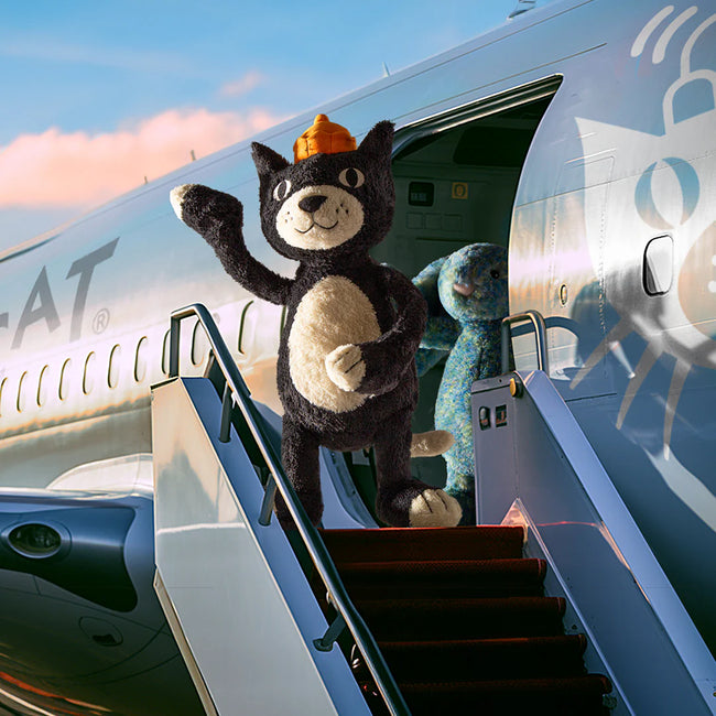 Jellycat jack waving outside a plane