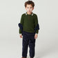 Young boy with curly hair wears Copenhagen Colors Boys’ Knitted Waffle Polo Long-Sleeved Polo, dark pants, and brown shoes, standing with a serious expression.