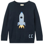 The Copenhagen Colors Baby Boys’ and Boys’ Rocket Sweater is navy blue, featuring a blue and white rocket with yellow flames and “C.C.” on the lower right side.