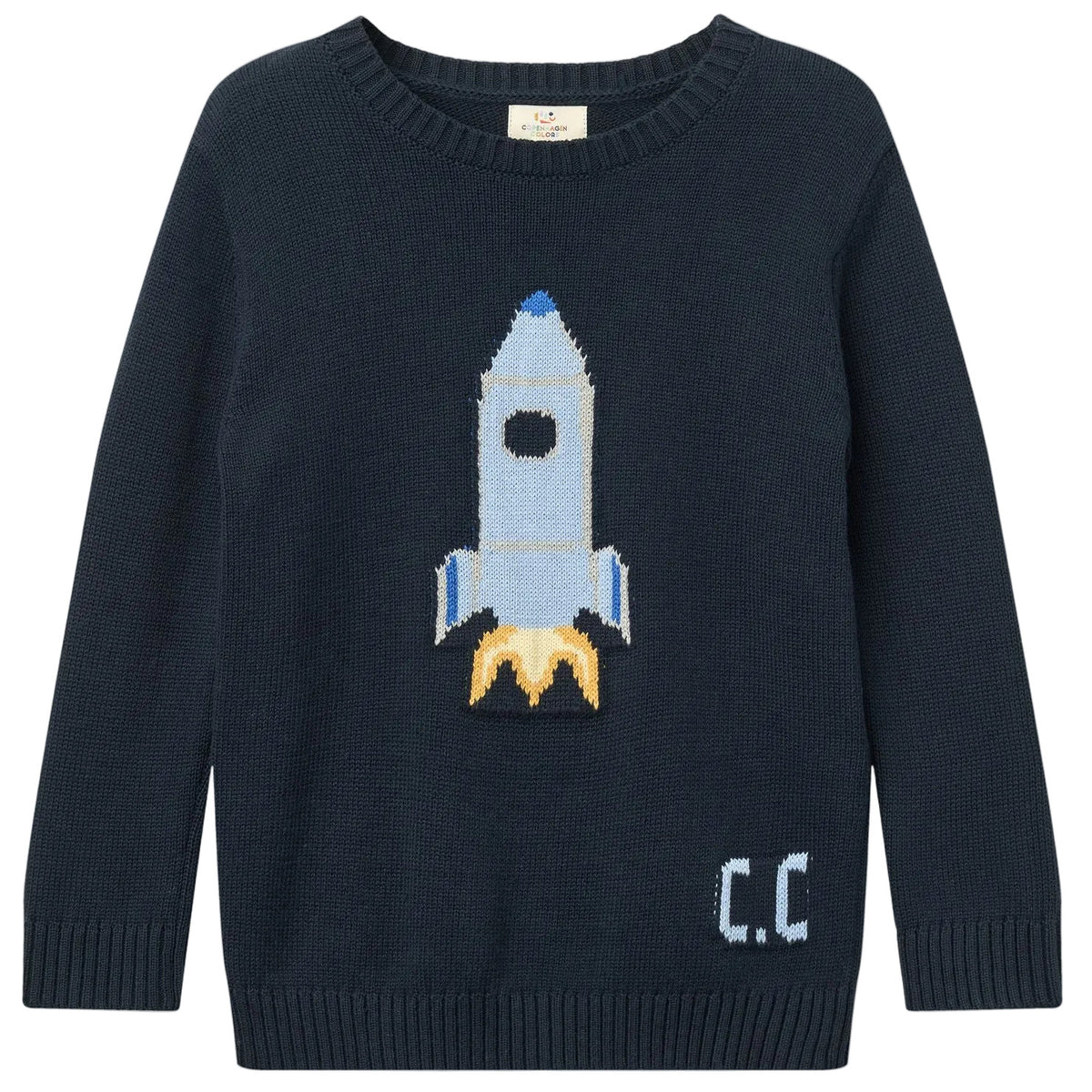 The Copenhagen Colors Baby Boys’ and Boys’ Rocket Sweater is navy blue, featuring a blue and white rocket with yellow flames and “C.C.” on the lower right side.