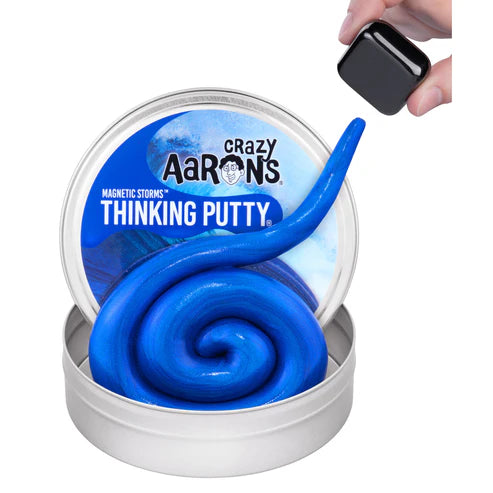 A tin of Crazy Aaron’s Tidal Wave Magnetic Storm Thinking Putty is shaped into a spiral, with a hand holding a black magnet above the magnetic putty—making this sensory toy ideal for interactive fun.