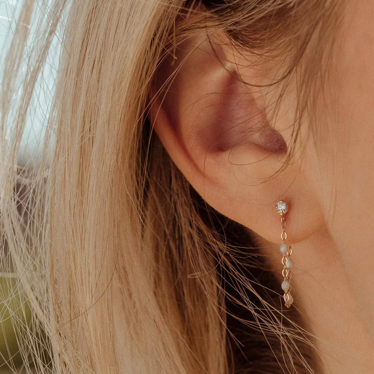 Close-up of a person's ear wearing Gigi Clozeau's Classic Gigi Earrings, showcasing a delicate design.