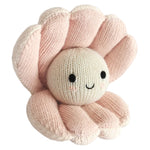 Introducing Baby Pearl by Cuddle + Kind—a handcrafted knitted plush toy shaped like a pink clam, featuring a round pearl center with a sweet smiling face, black eyes, and a simple stitched mouth. Made from natural Peruvian cotton, Baby Pearl is the perfect soft companion for your baby.