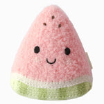 The Cuddle + Kind Baby Watermelon is a handcrafted cotton plush toy shaped like a smiling pink watermelon slice, complete with black eyes and brown seed details on a white background—a soft and delightful companion for little ones.