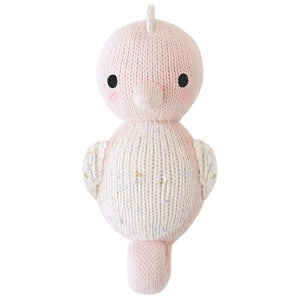 A hand-knit Baby Seahorse in powder pink by Cuddle + Kind, crafted from heirloom-quality Peruvian cotton yarn, is shown from the front against a white background.