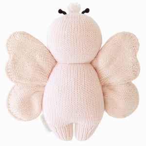 The Cuddle + Kind Baby Butterfly - Petal Pink is a soft, heirloom-quality plush toy featuring light pink wings and body, shown from the back.
